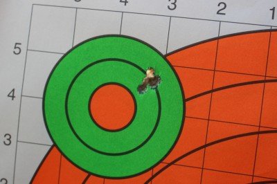 vHow’s this for a five round group? While I’d hoped to have that ragged hole right in the orange dot, this type of reliability is admirable from a stock AR. There are a lot of ARs, many of which are much more expensive, that won’t shoot half this well. 