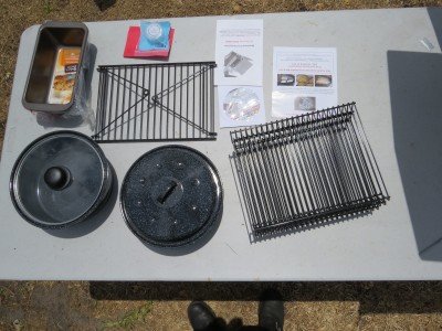 The$399  Sun Oven kit comes with a swinging leveling rack, three stackable drying racks, two pots, two baking pans and directions for everything.  The $349 doesn't have the pans.