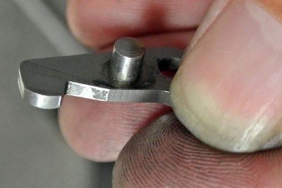 This is the cylinder latch.  The rounded off edges engage the cylinder. 