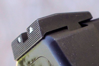 The rear sights combine flat black serrations and small whit dots. 