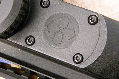 The sealed buttons behind the battery cap (arrows) are used to program the ballistic computer and to set illumination intensity.