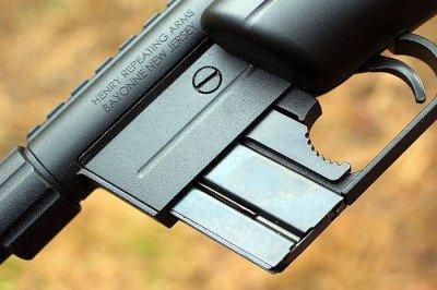 The magazine fits flush with the trigger guard, and is released by the lever that looks like it has a bite taken out of it. 