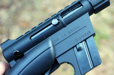 The charging handle, the little nub pictured here, slides back into the bolt, which keeps it out of the way. 