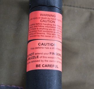 I bought the gun new so there were standard safety warnings on the stock, which is better than stamping them into the gun. 