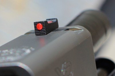 The front sight, a red fiber optic bead, glows brightly. 