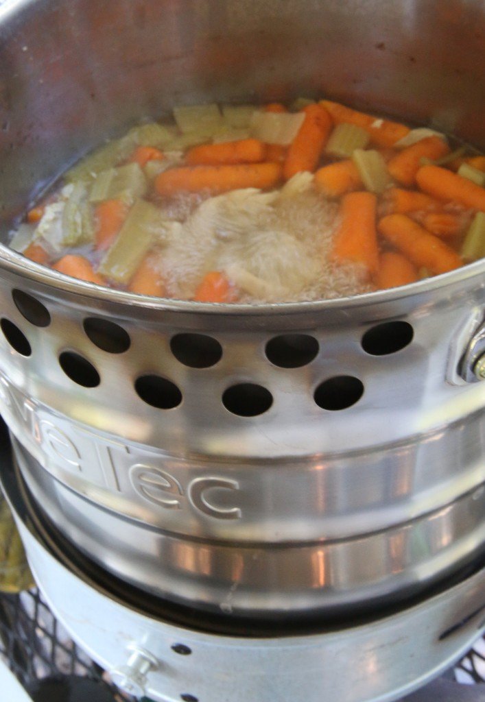 For my second batch, I decided to can some leftover chicken soup. Hot soup has the same canning time as raw veggies if you boil the soup first, so I used the handy rocket stove pot. 