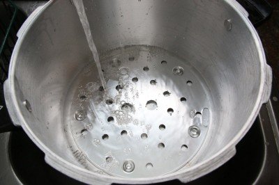 You only need a few inches of water in your canner. Very little steam escapes even over an hour or more with the weight on.