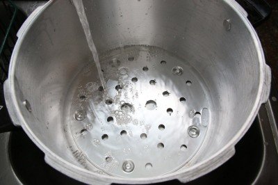 You only need a few inches of water in your canner. Very little steam escapes even over an hour or more with the weight on.