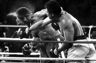 FILE - In this Oct. 30, 1974, file photo, perspiration flies from the head of defending champion George Foreman as he takes a right from challenger Muhammad Ali in the seventh round in their world heavyweight championship bout dubbed "Rumble in the Jungle" in Kinshasa, Zaire. Ali regained the world heavyweight crown by knocking out Foreman in the eighth round. (AP Photo/Ed Kolenovsky)