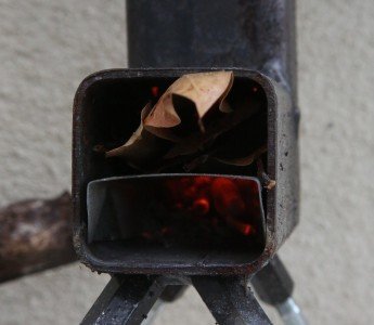 Leaves are easy to smother your fire, but if you are careful, thick leaves like these Mango leaves actually have a decent amount of BTUs in them.  You can put them in the top too. 