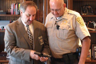 "DeKalb County Sheriff Jimmy Harris inspects the new shipment of concealed carry handguns for his deputies."  (Photo: YellowHammer News)