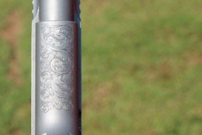 The mainspring housing is engraved. The front strap is not.