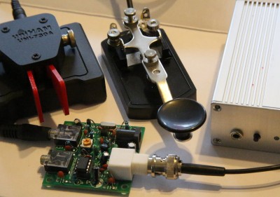 The radio on the right is a completely assembled Rock Mite PIC chip radio. The green board is the Pixie. The red key is the $50 electronic iambic keyer, and the black one is the standard straight key. 
