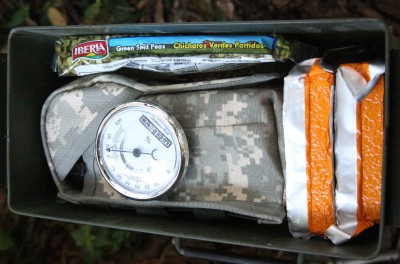 An AR, six full mags, some ready food and some cookable dried food, all packed up. Note the humidity level. 
