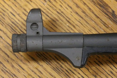 Barrel nut with hooded sight can screw on flip up cap or suppressor.