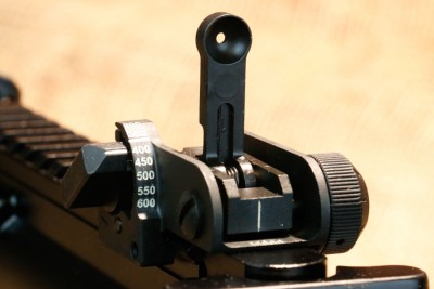 The rear sight is windage and elevation adjustable with a single flip up aperture