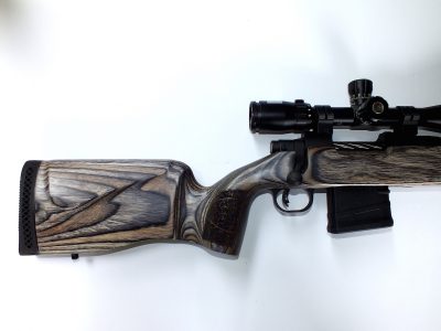 The laminated stock uses a stippling pattern for grip, has a vertical pistol grip, and a comfortable recoil pad. 