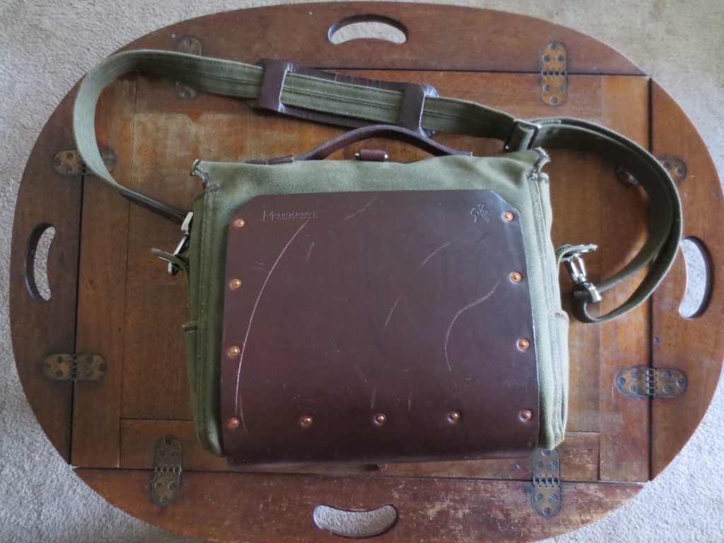 The Old Bull full-grain leather pad affixed to the back of the green canvas bag with copper rivets. You can see I put several big scratches on the pad, by accident. 