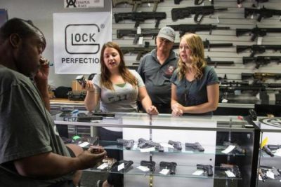 At the Get Loaded gun store in Grand Terrace, store managers Jamie Taflinger, left, and Kendyll Murray show customer Cornell Hall of Highland different types of ammo. (Gina Ferazzi / Los Angeles Times)