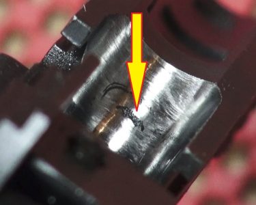 The 1911Ps seem to have a flaw in the feed ramp (see arrow) that can add to feeding problems. Certain magazine brands appear to be more affected by this than the stock magazine.