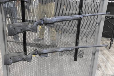 Two rifles sit on a wall rack.