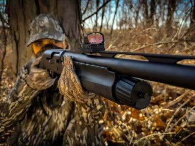 Hunter in the field with a shotgun featuring the Burris optic mount.
