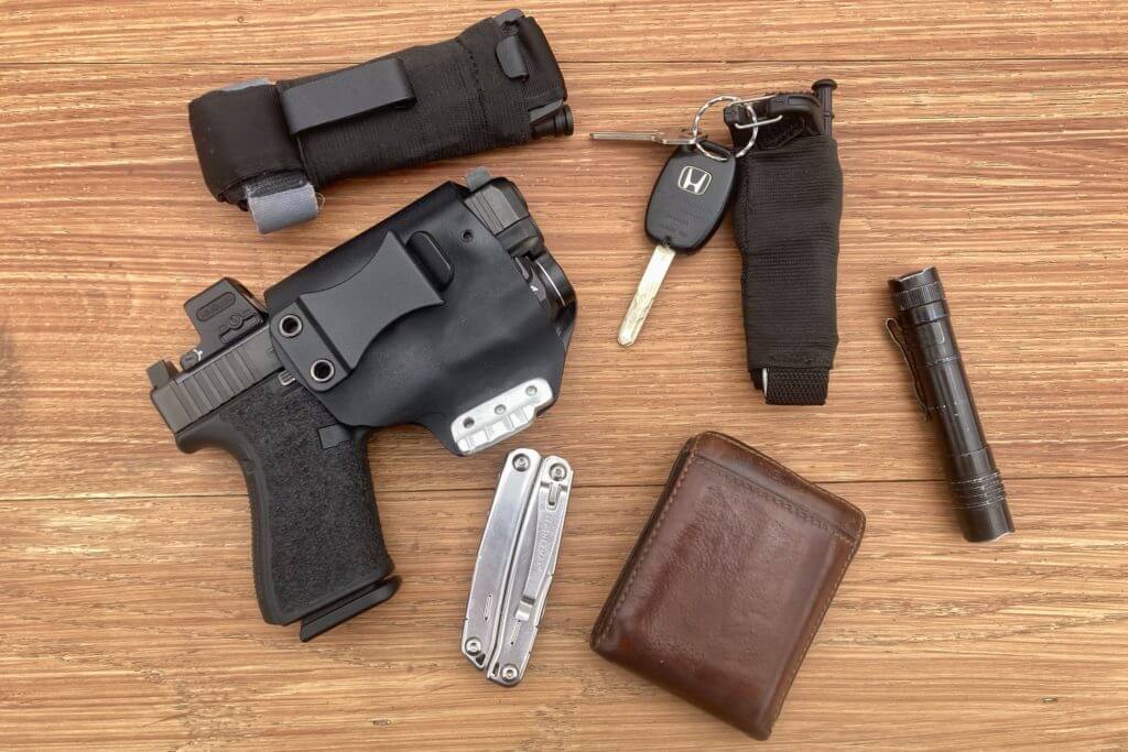 Glock 19, wallet, keys, multitool and tourniquets on table