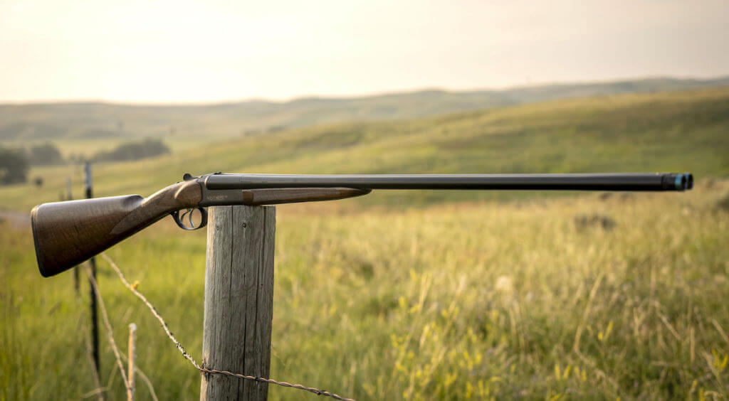 A Weatherby shotgun on a fence post.