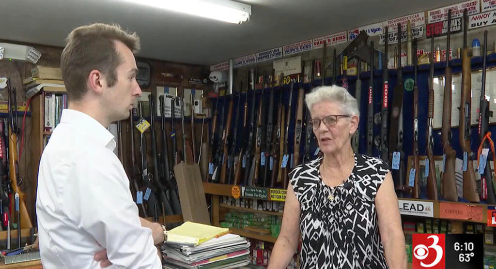 A reporter and a manager at a gun shop.