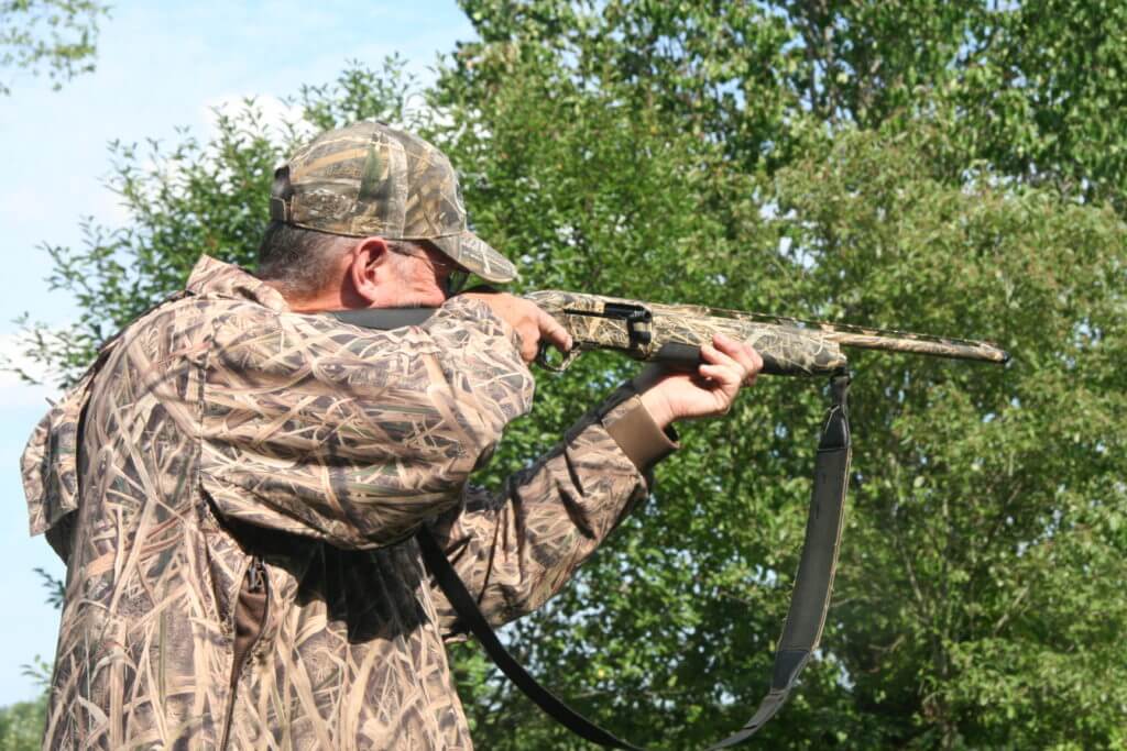 Hunter in camo shirt and hat aiming the Beretta A-400 