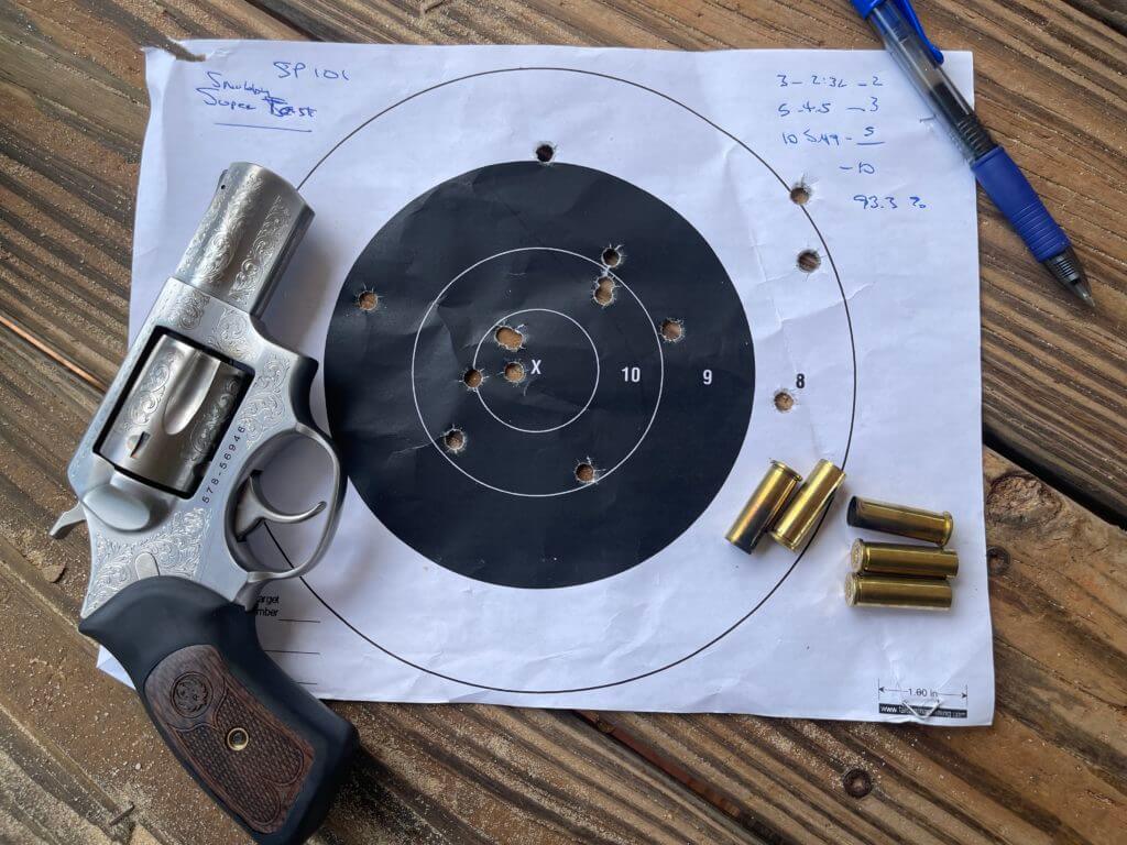 The SP101 with a used target and brass casings on a wooden table