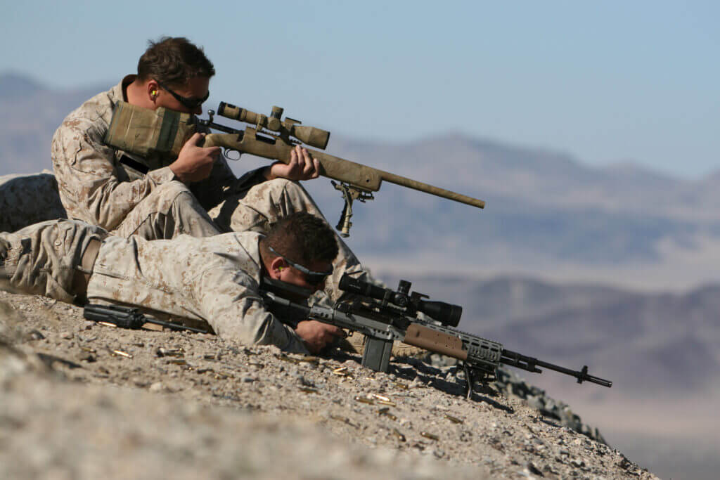 United States Marine Corps troops shooting guns on rock
