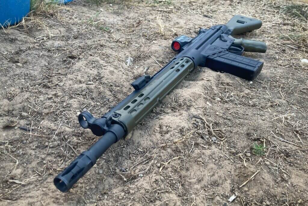 Rifle on dry grass and dirt