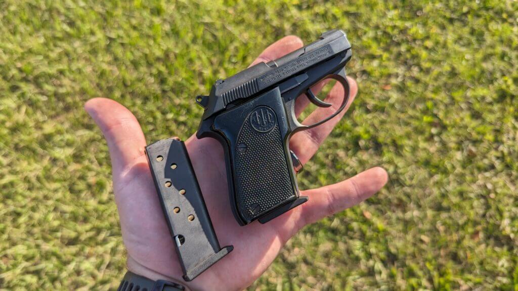3 - The Beretta Tomcat - Micro-Sized Bite Beretta Tomcat sitting with extra loaded magazine on human palm