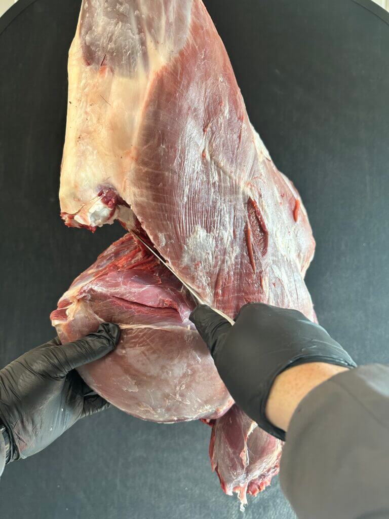 3-November-How to Cut the Humble Hindquarter Gloved hands using a knife to deal with the sirloin tip