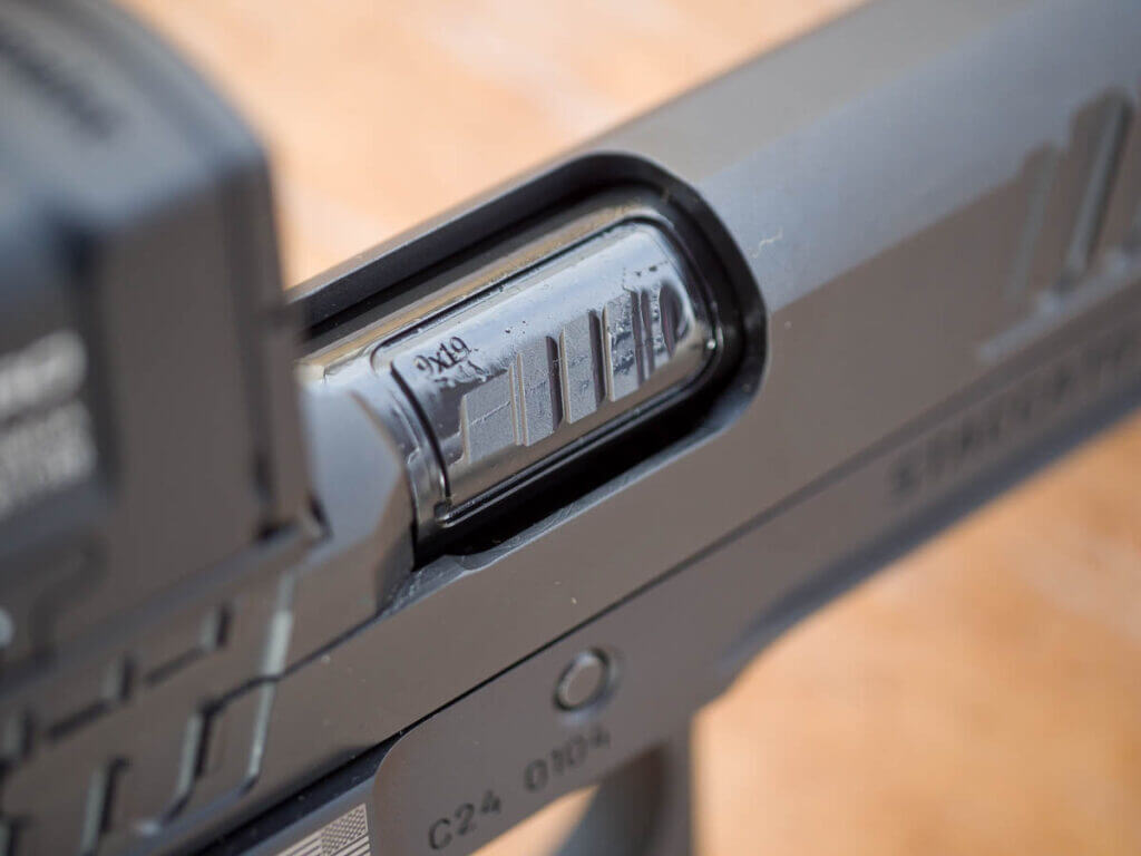 Close up view of the ejection port closed. 9x19 is stamped on the barrel.