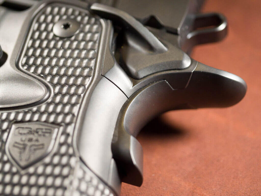 Close up of the grip safety and textured grips. The gun is facing to the left.