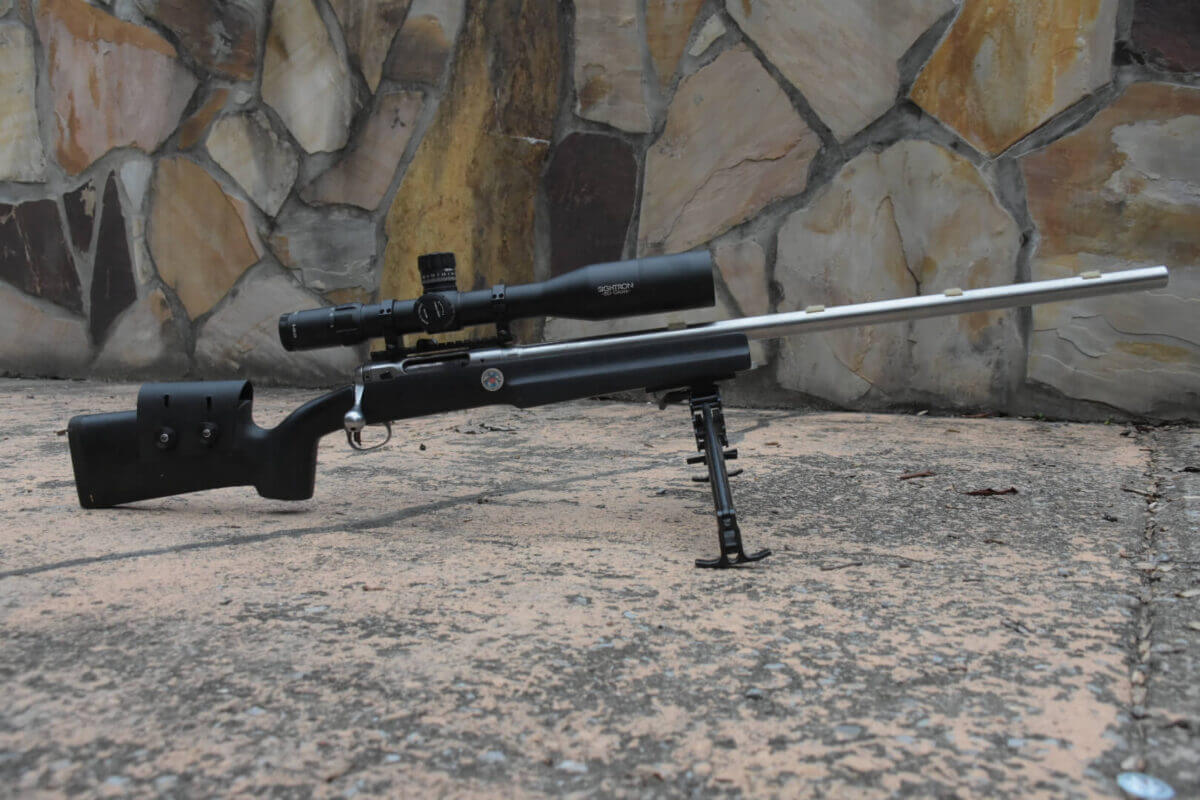 Sightron SVIII A rifle rests on a bipod with a stone background.