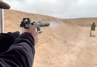 Shooting a suppressed handgun in the desert.