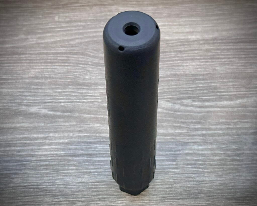 a suppressor sits on a table. 