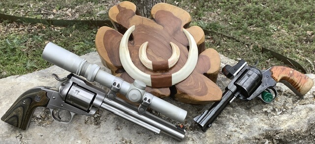 pistols in front of wild boar tusks