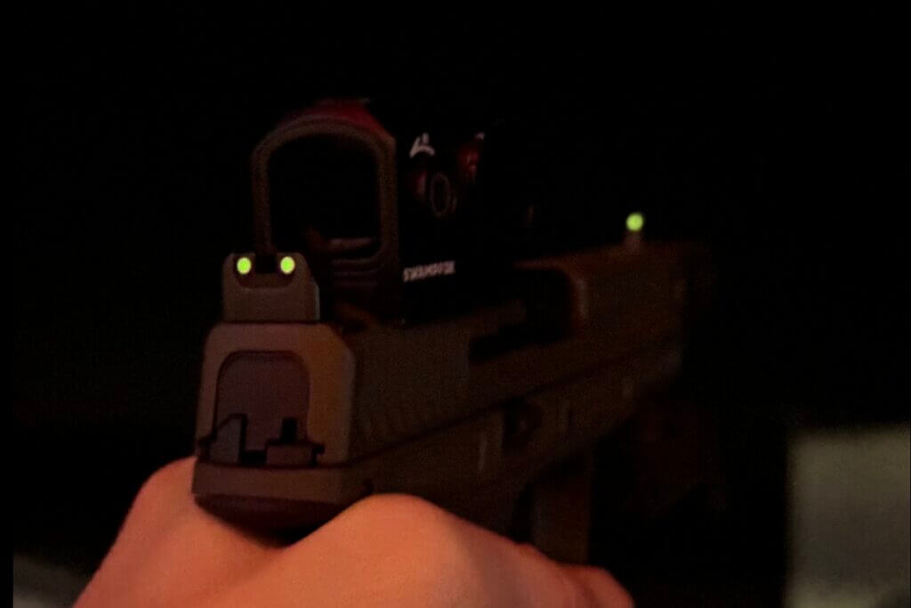 Dark image of handgun with red dot