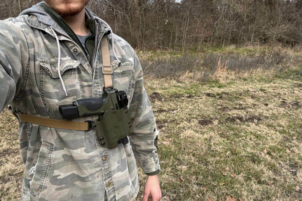 Shooter with Smith and Wesson handgun strapped to his chest outside