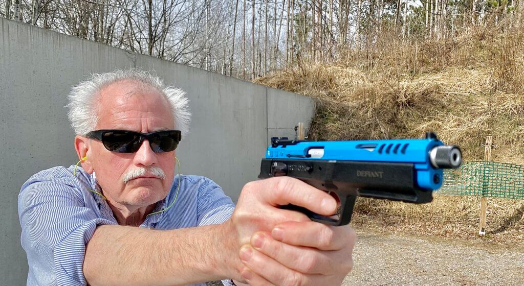 Shooter holding the blue Force 22 TB rimfire pistol outiside