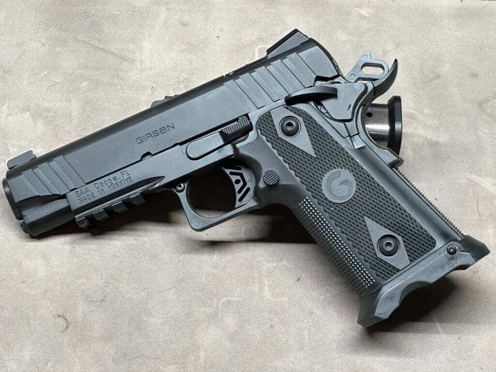 The Girsan Witness2311 is posed on a tan table top.