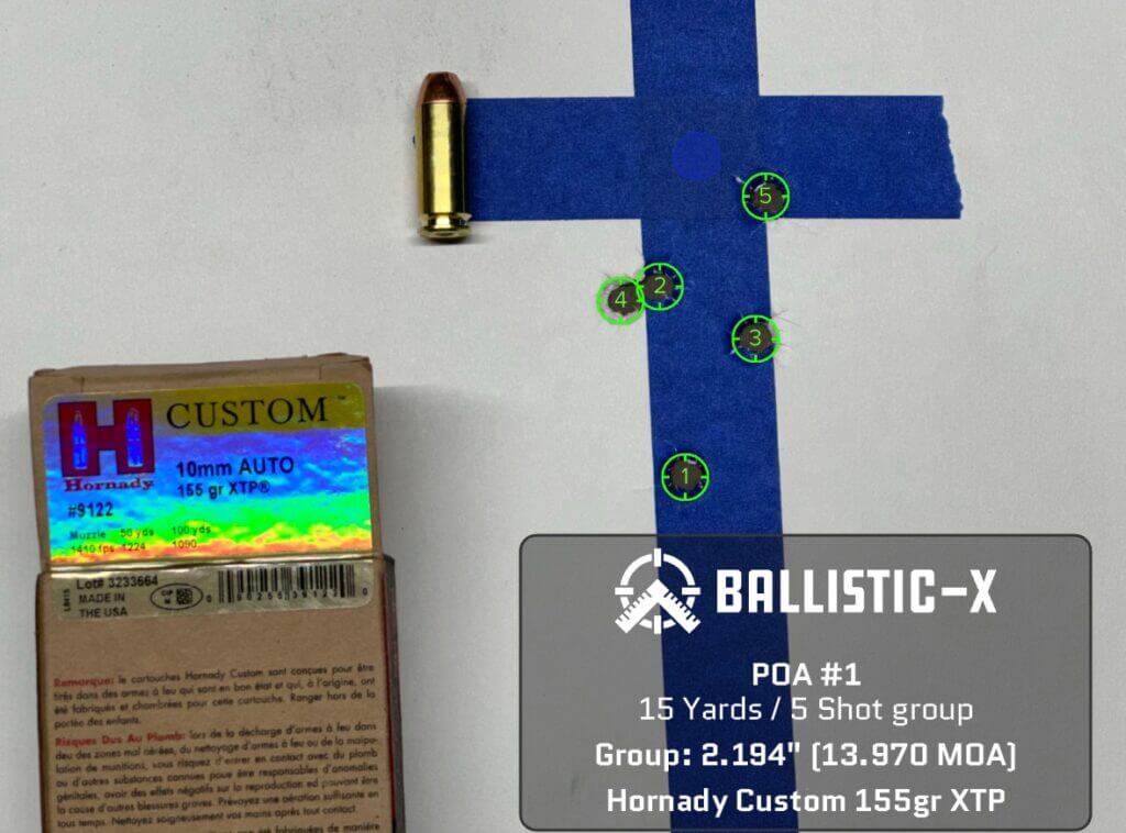 Five bullet holes are grouped on a target.