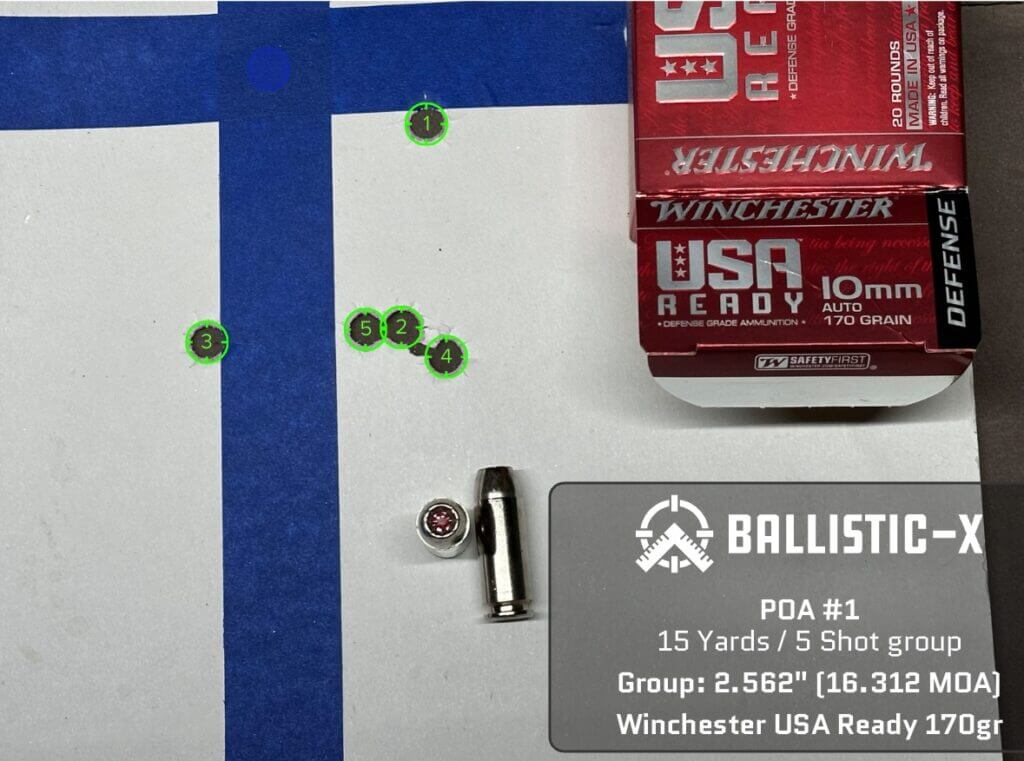 Five bullet holes are grouped on a target.