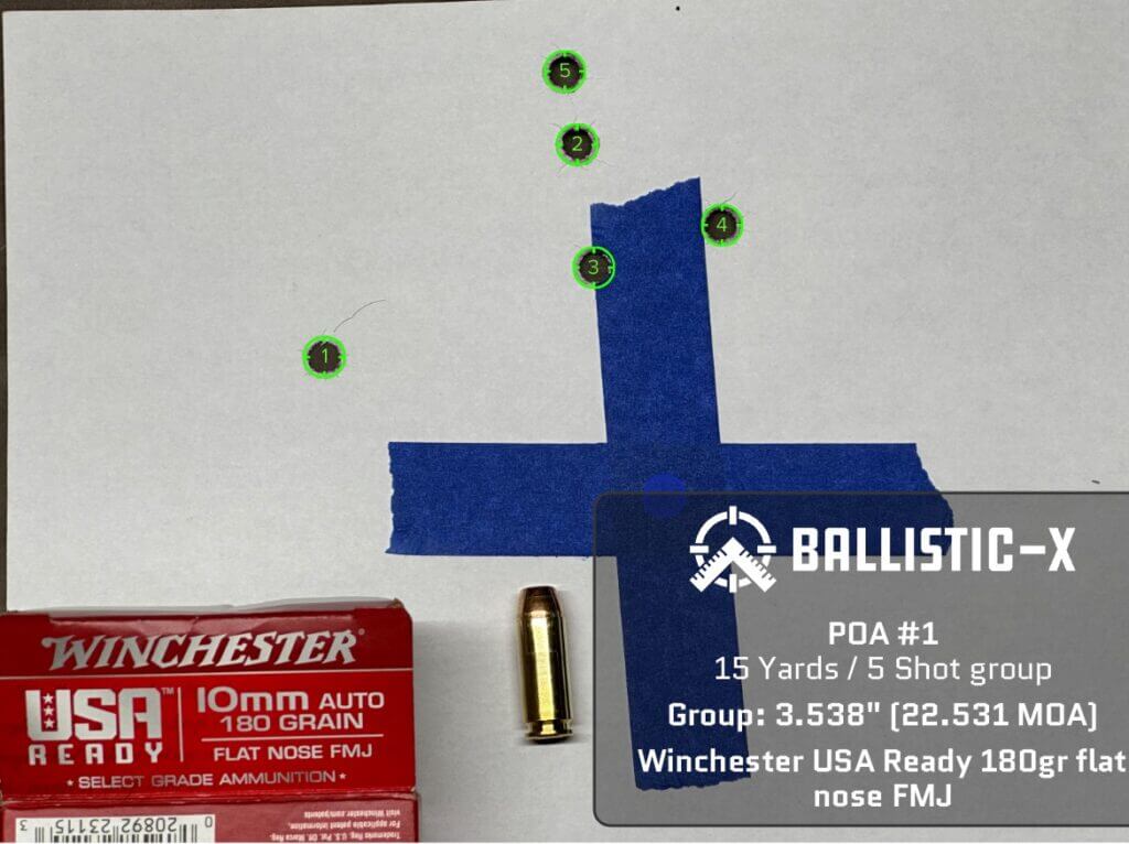 Five bullet holes are grouped on a target.