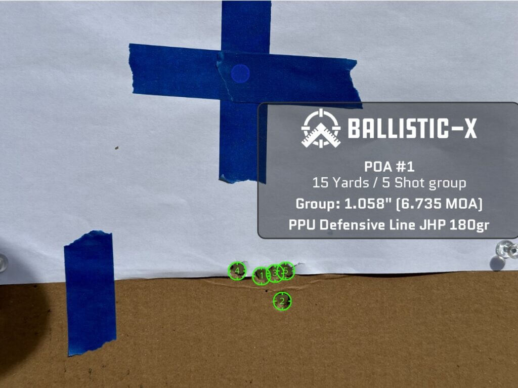 Five bullet holes are grouped on a target.