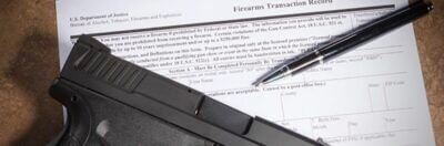 A gun and a pen on a form 4473 form.